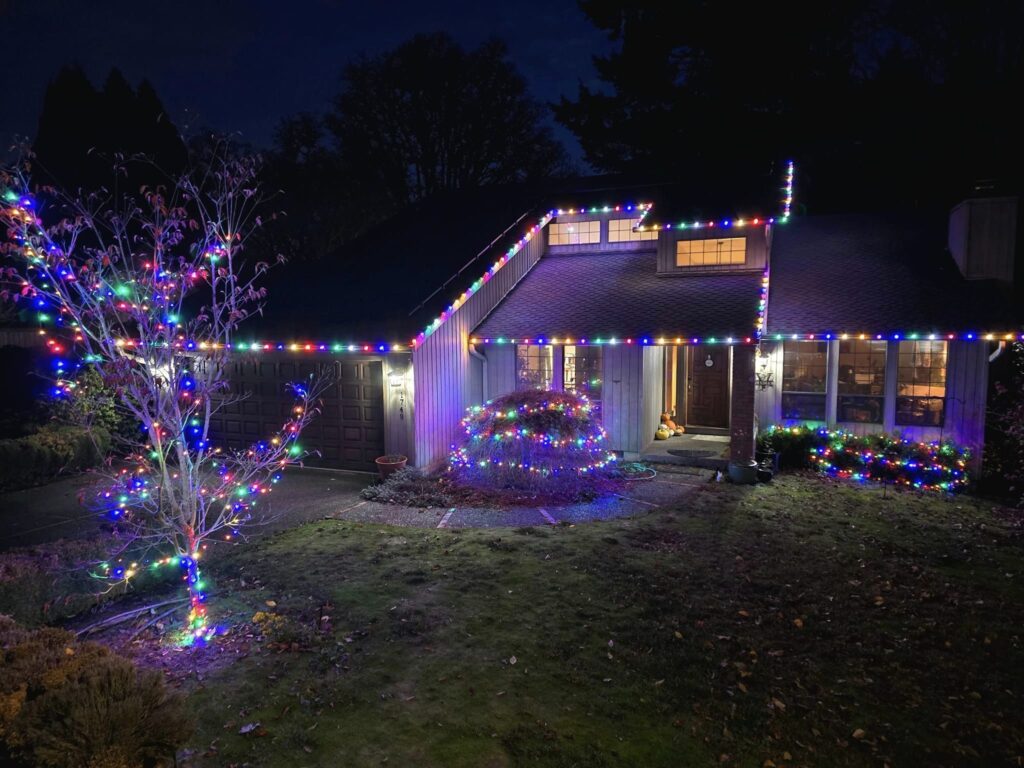 House decorated with colorful Christmas lights at night.