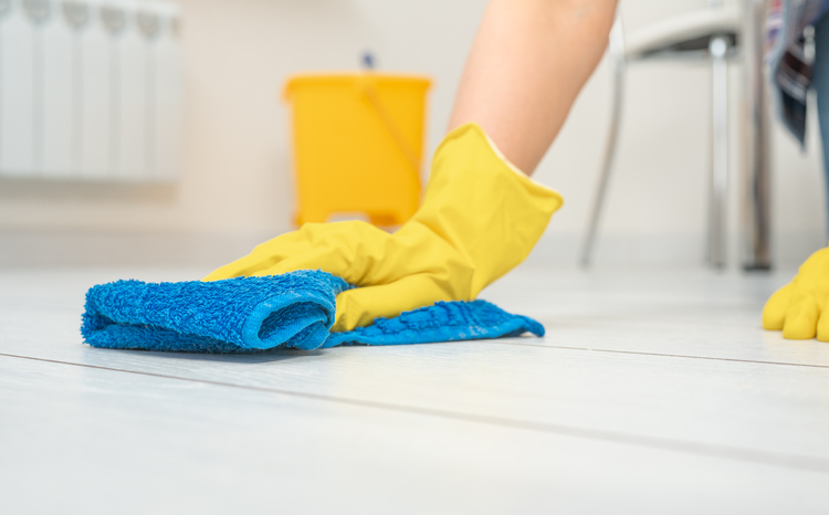 woman thoroughly and gently washing and cleaning white laminate floor